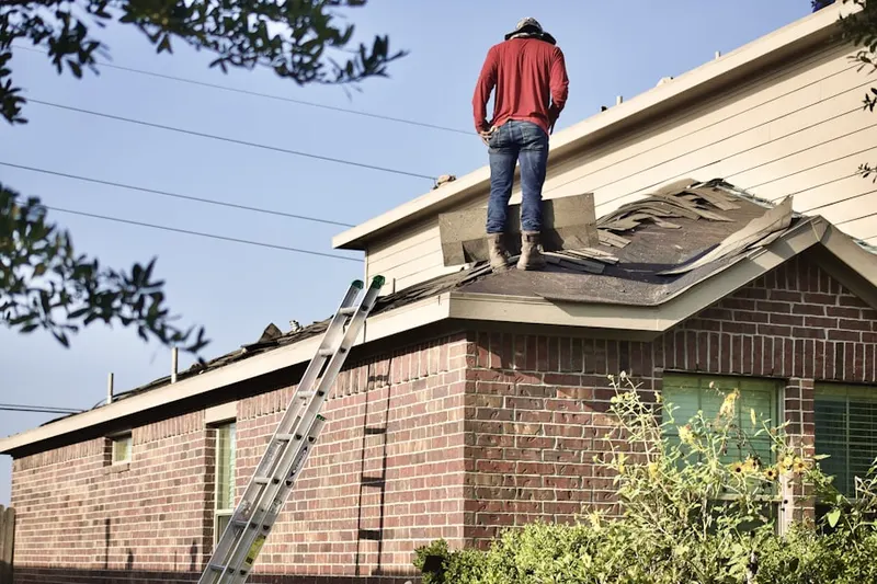 Professional roofer working on a residential roof in Golda Meir Kent Jewish Center